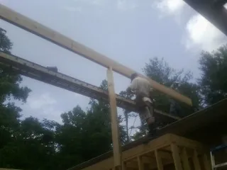 Carpenter setting a ridge beam over a new addition frame — Ice Dam Removal by Roofing Brothers in Shinnston