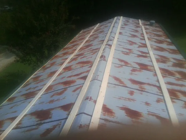 Rusted metal roof panels with new wood purlins before replacement — Storm Damage Roof Repair in Shinnston by Roofing Brothers