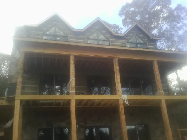 Dormers and porch framing on a large log home under construction — Roof Coating work by our crew in Shinnston