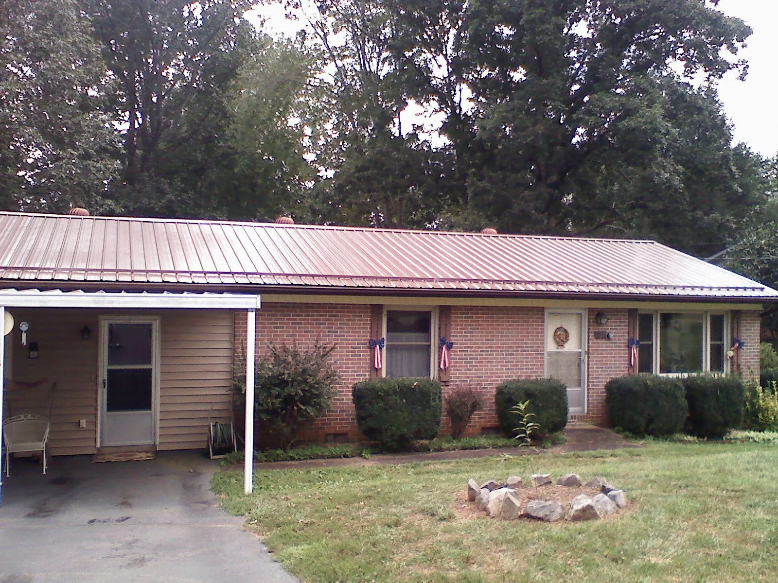 Bronze metal roof and carport on a brick ranch home — Roof Repair work by our crew in Shinnston
